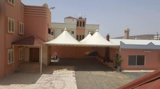 مظلتان هرميتان بيضاوان متجاورتان فوق مدخل حوش منزل
